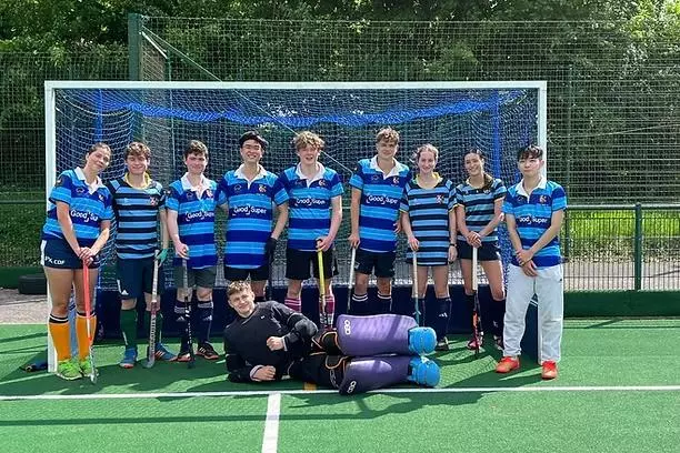The Trinity College Hockey team stood in front of a goal