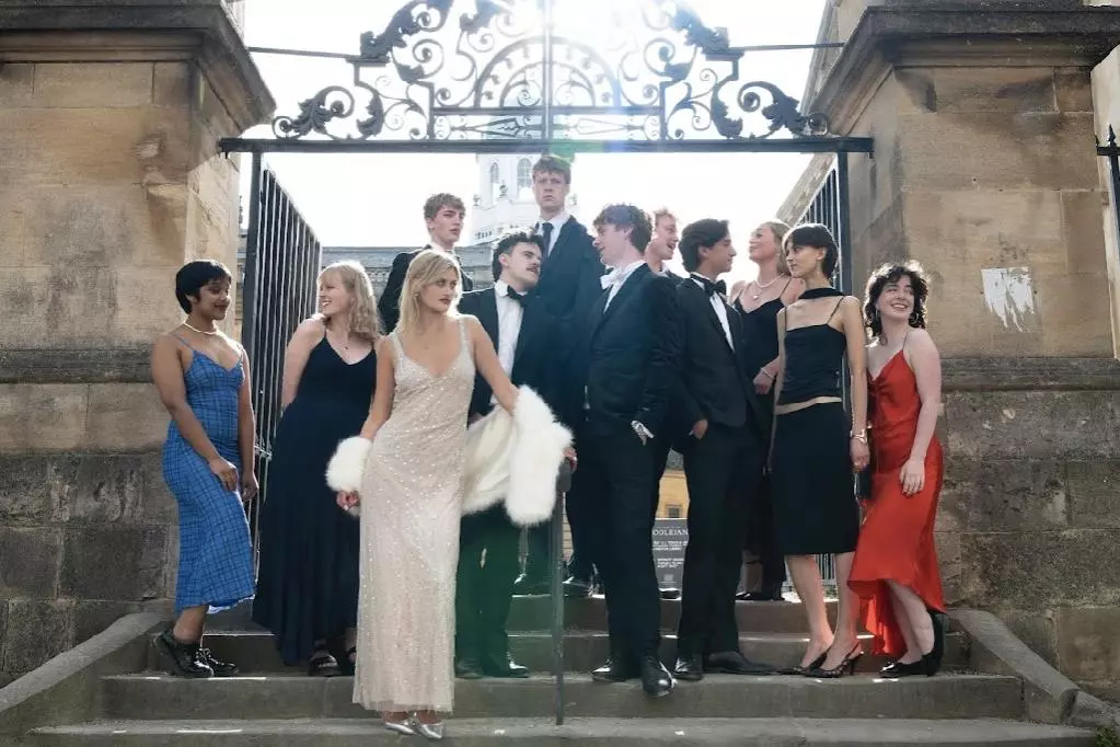 Actors from the Trinity players posing in front of a gate