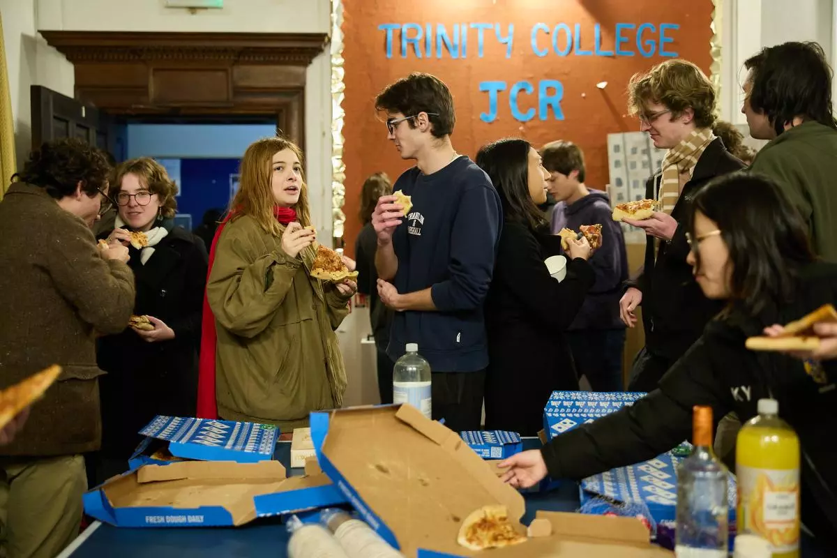 Members of the JCR eating pizza at a welfare event in the JCR